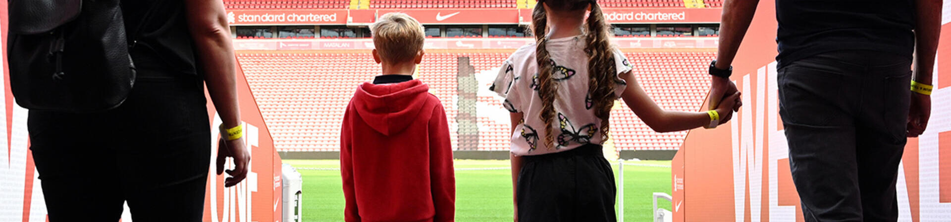 A family walking through the Tunnel to view the pitch as part of the stadium tour.