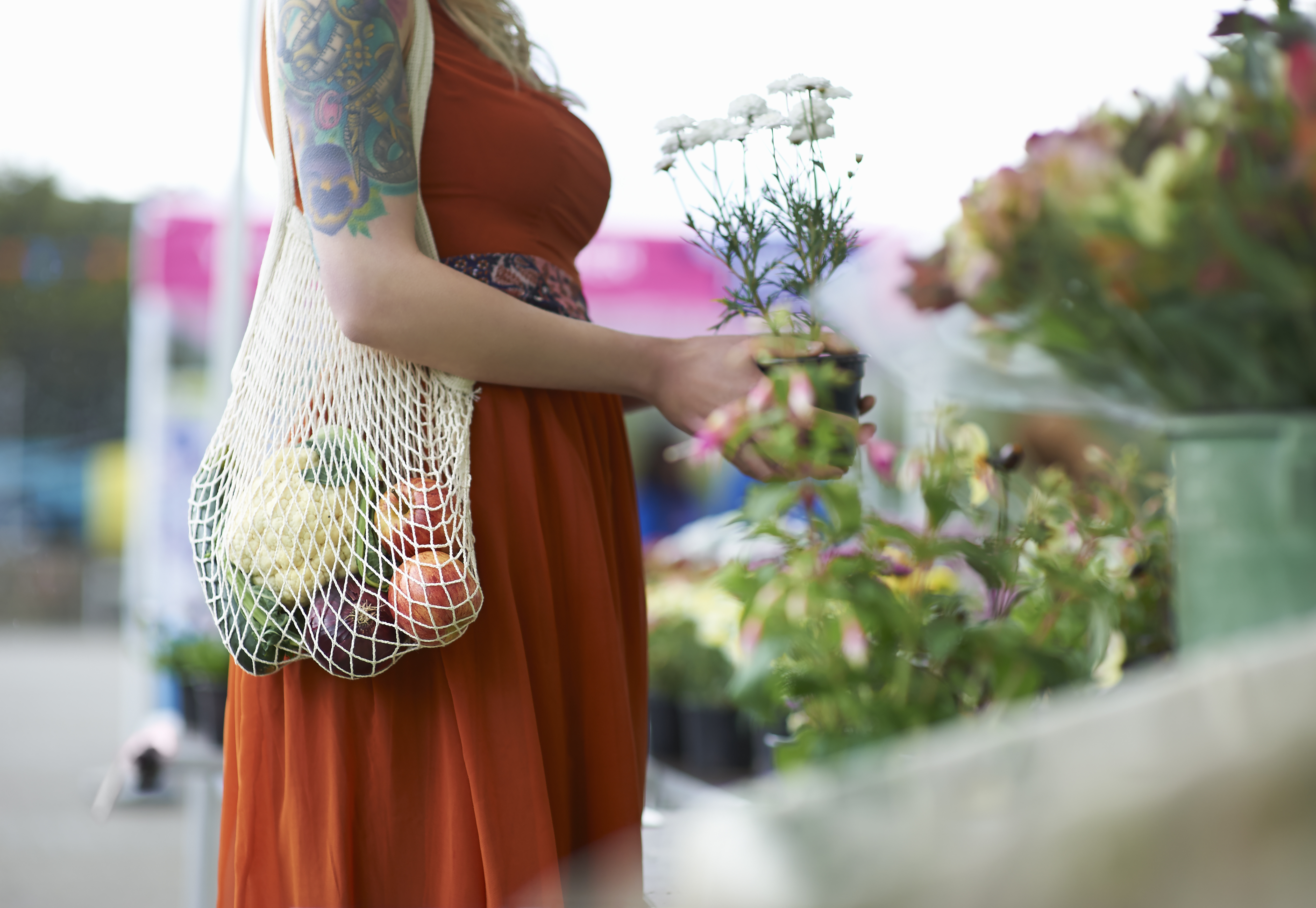 Woman shopping on local market with plastic free reusable bag.
