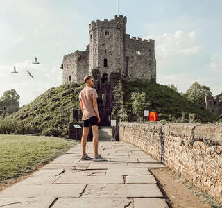 Man standing on a path in front of a castle