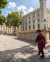 Beefeater caminando junto a la Torre de Londres en un día soleado