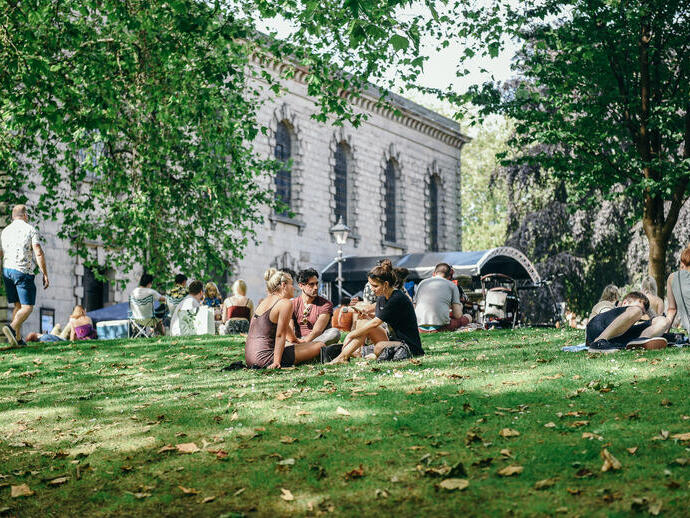 Grupos de personas sentadas en una pendiente cubierta de hierba en el barrio Jewellery Quarter de Birmingham
