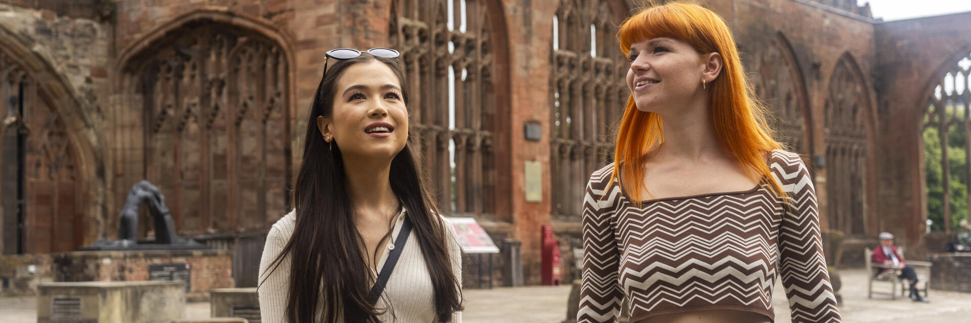 Two women explore the ruins within the grounds of a Cathedral