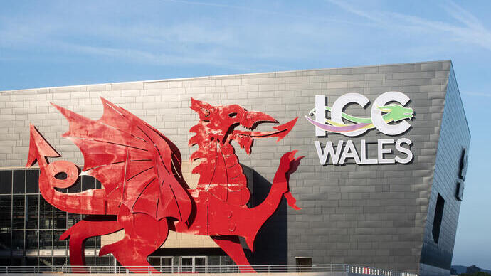 Convention Centre exterior in daylight, featuring a red Welsh dragon and a sign reading: ICC Wales.