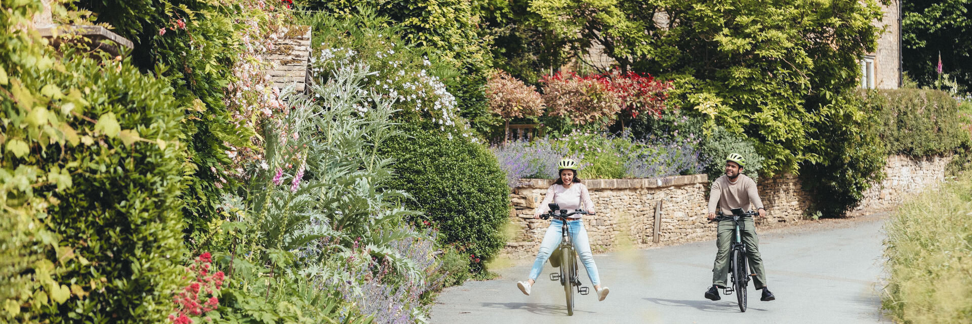 A man and and woman cycle through a quaint village