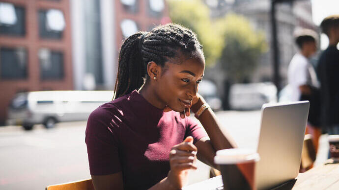 Woman using a laptop at an outdoor café