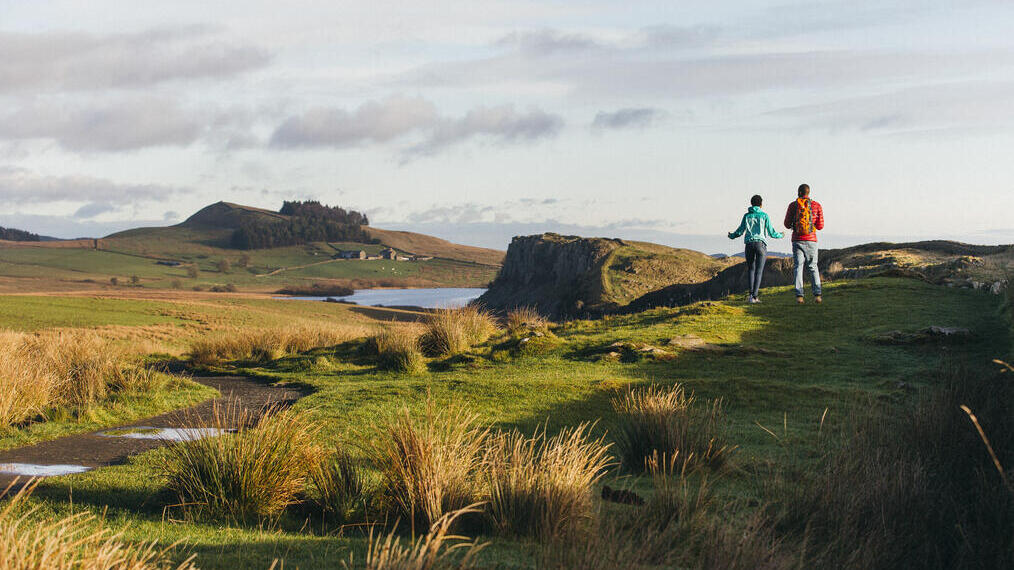 Two young adults walking the Northumberland, UK countryside.