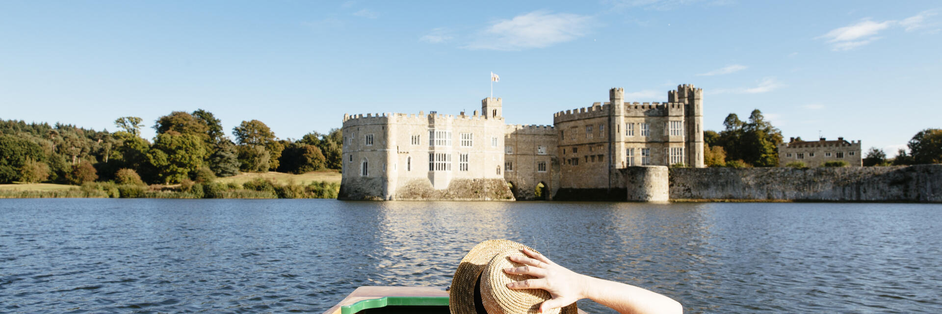 Frau in einem Boot auf dem Burggraben mit Blick auf die Burg