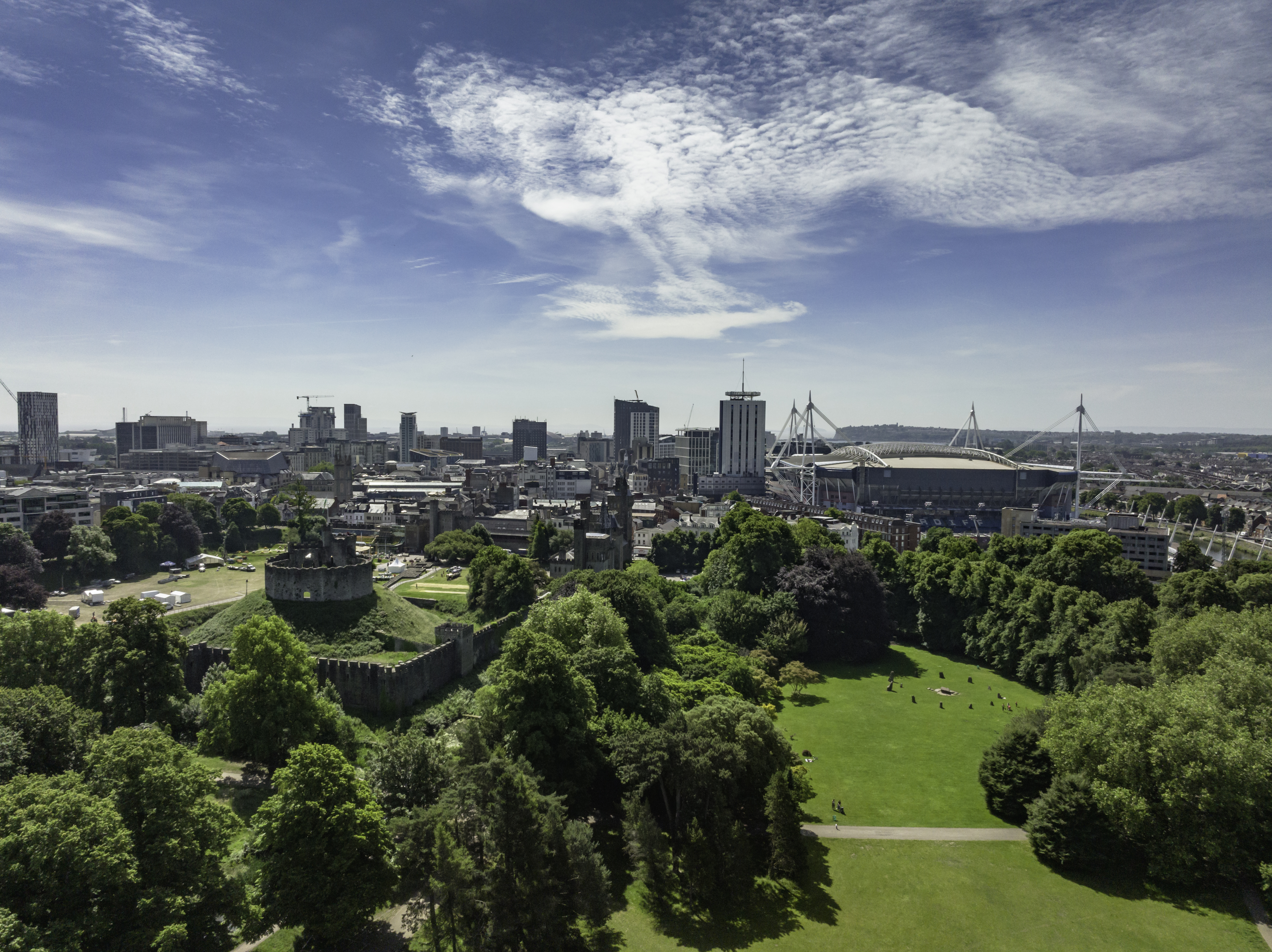 View of Bute Park, Cardiff from above, with green trees in the foreground and blue skies