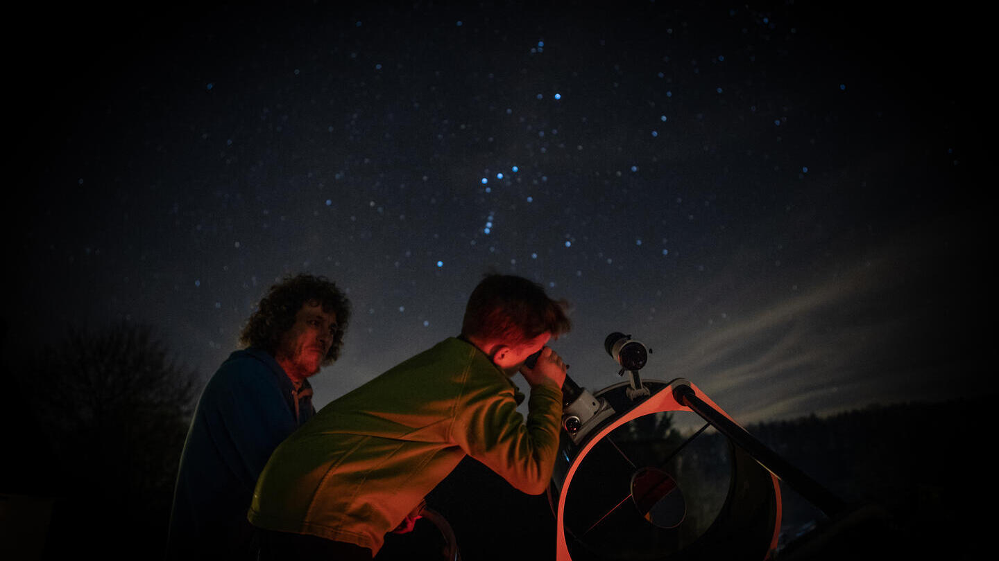 Enfant observant les étoiles à travers un télescope