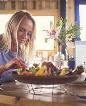 Blond woman and man sitting at table, eating seafood platter