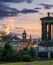 Fireworks at dusk in the sky over city monuments