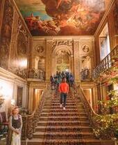 Group of people walking down stairs under a painted ceiling