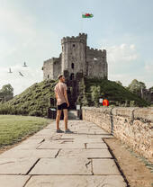Man standing on a path in front of a castle