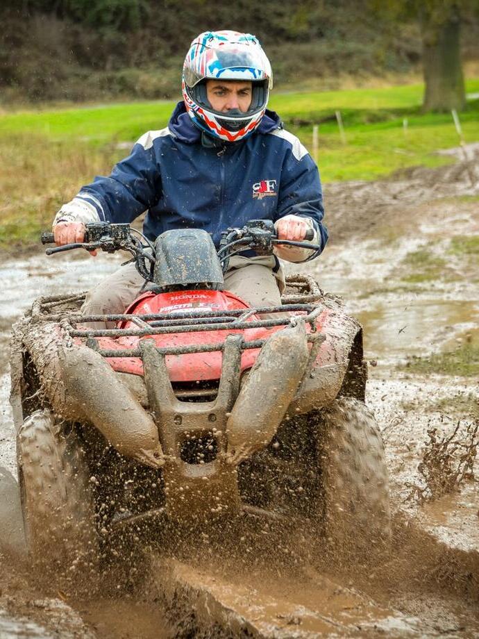 Ein Mann, der mit einem Quad auf einer schlammigen Strecke fährt