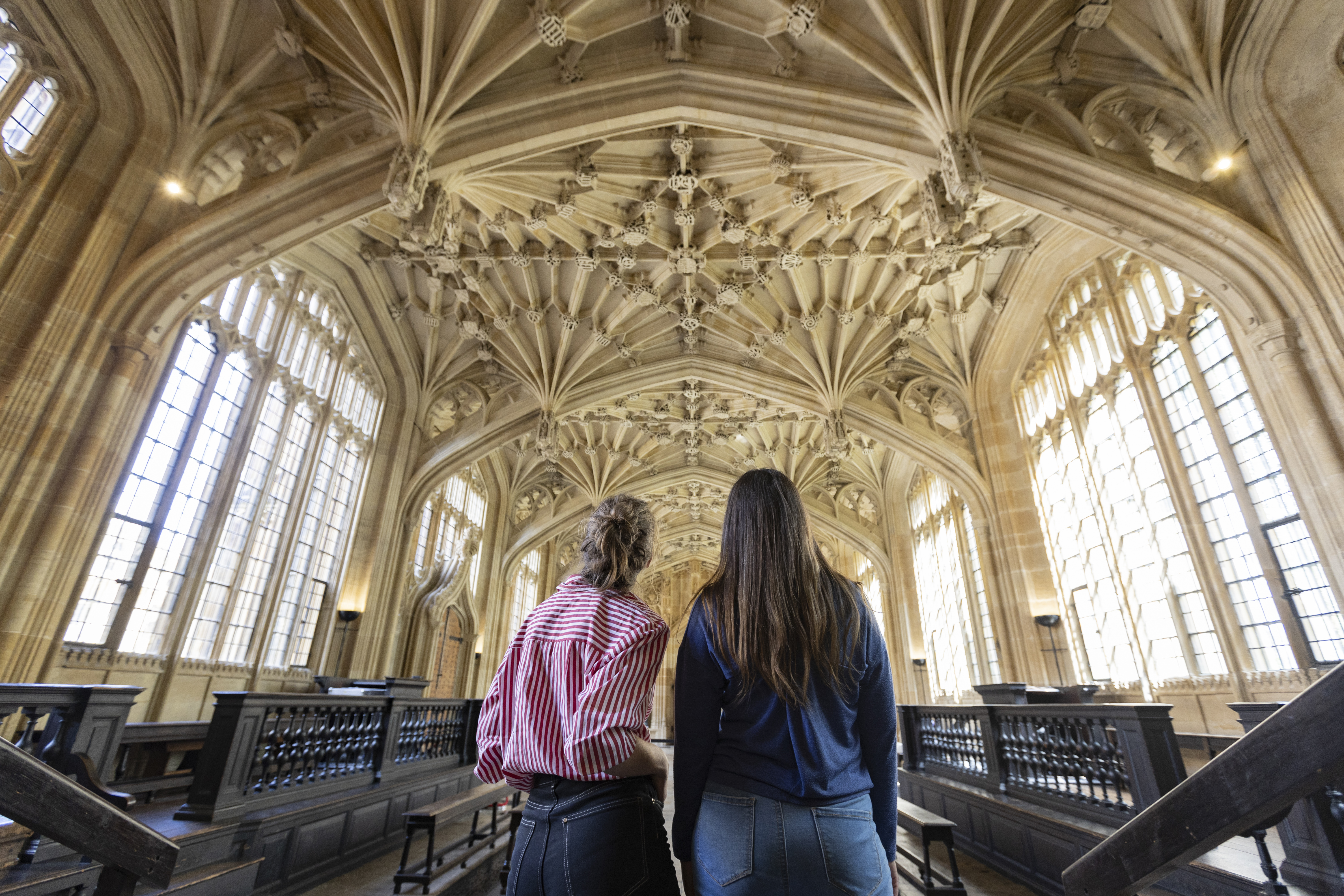 Two women look up towards an ornate ceiling