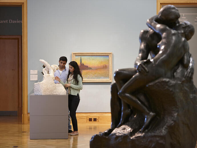 رجل وامرأة يشاهدان أعمالًا فنية في متحف