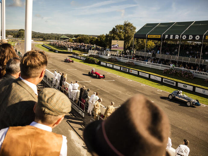 People in a grandstand watching a vintage sports car race