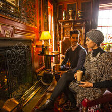 A young Arab couple relaxing by a fire in the drawing room