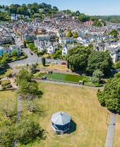 View over a rotunda in a park, overlooking a picturesque village.
