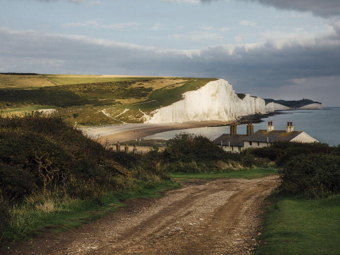 Cottages on the coast with sea and white cliffs in the background