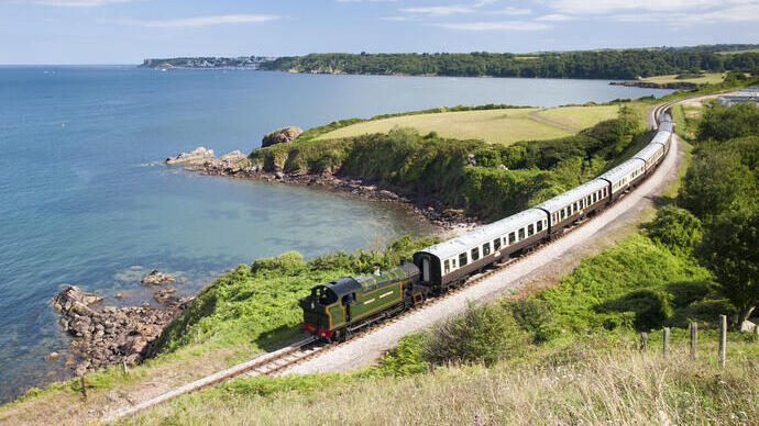 Treno a vapore su una linea ferroviaria che segue la costa