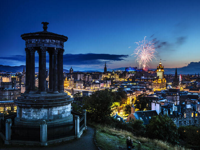 Night view from a hill of fireworks over a city centre