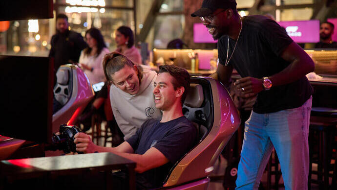 A group of friends enjoying a racing simulator game