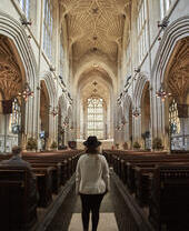 Femme marchant dans l'allée d'une abbaye