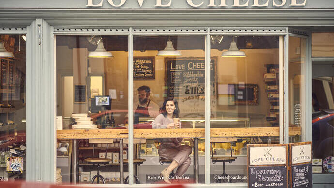 Woman sitting at a window table in a cheese cafe