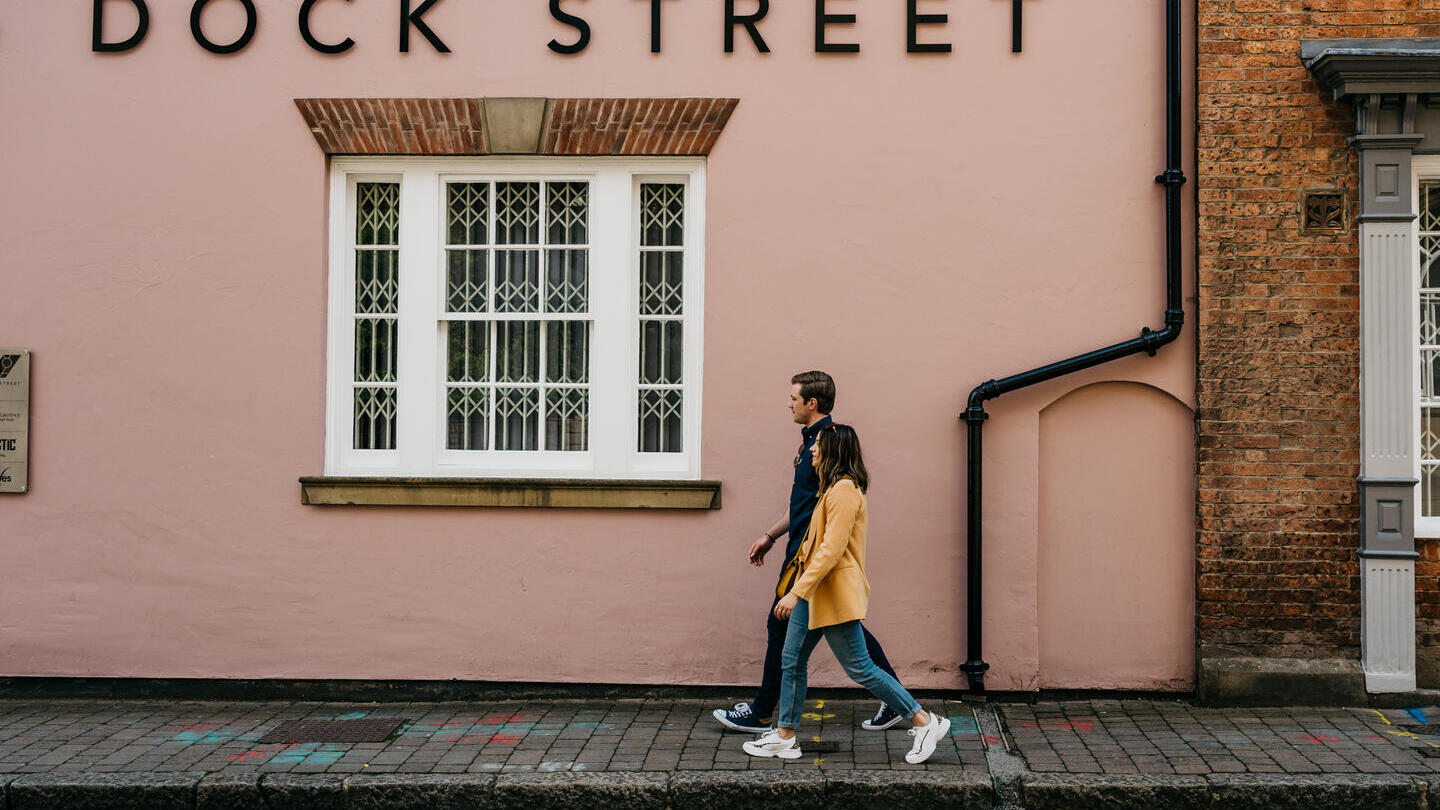 Two people walking in front of building