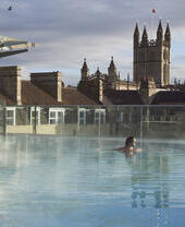 Woman in a roof top swimming pool at a spa