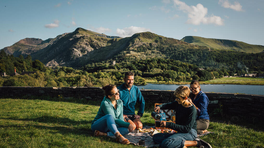 Friends having a picnic in grassland by a glacially formed lake.
