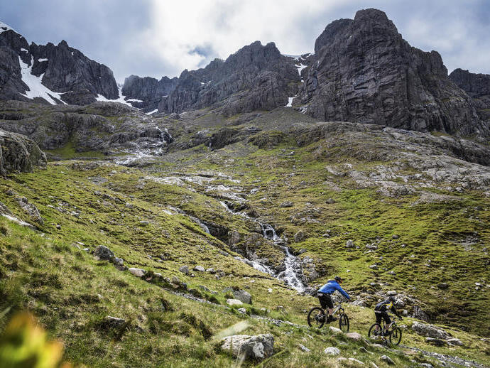 Two mountain bikers cycling down a mountain