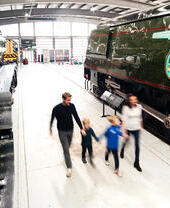 Family looking at locomotives on display in museum