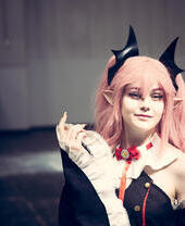 Eine Cosplayerin, gekleidet wie eine japanische Anime-Figur, mit bunter Perücke und Make-up bei einer Comic-Con-Veranstaltung