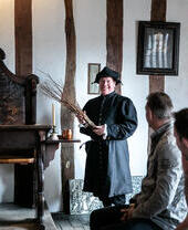 A tour guide showing exhibits at Shakespeare's Classroom in Stratford-upon-Avon