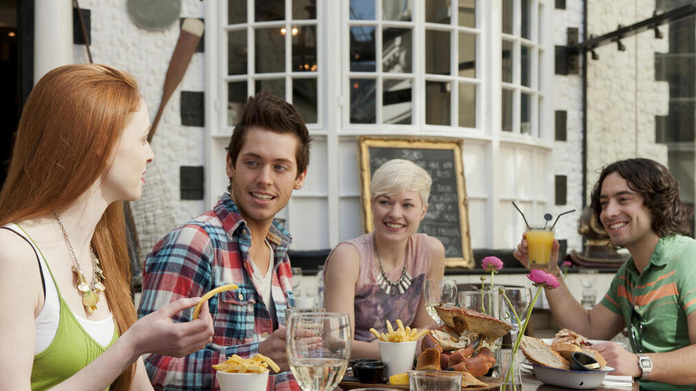 A group of people in a restaurant in Brighton, eating in the open air at Fishy Fishy restaurant.