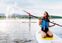 People paddle boarding in an estuary by the sea.