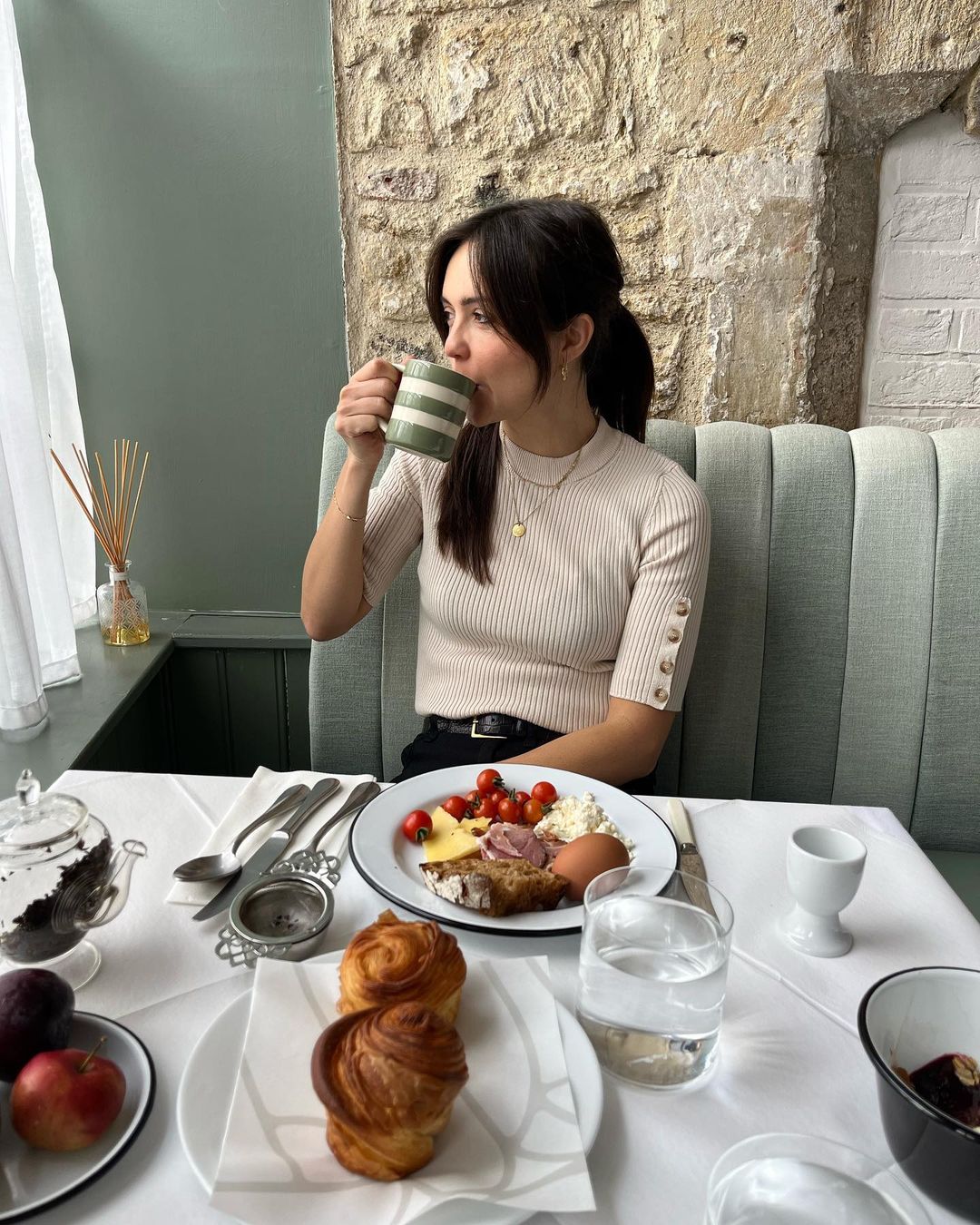 A woman eating and drinking Number One restaurant in Bruton, England