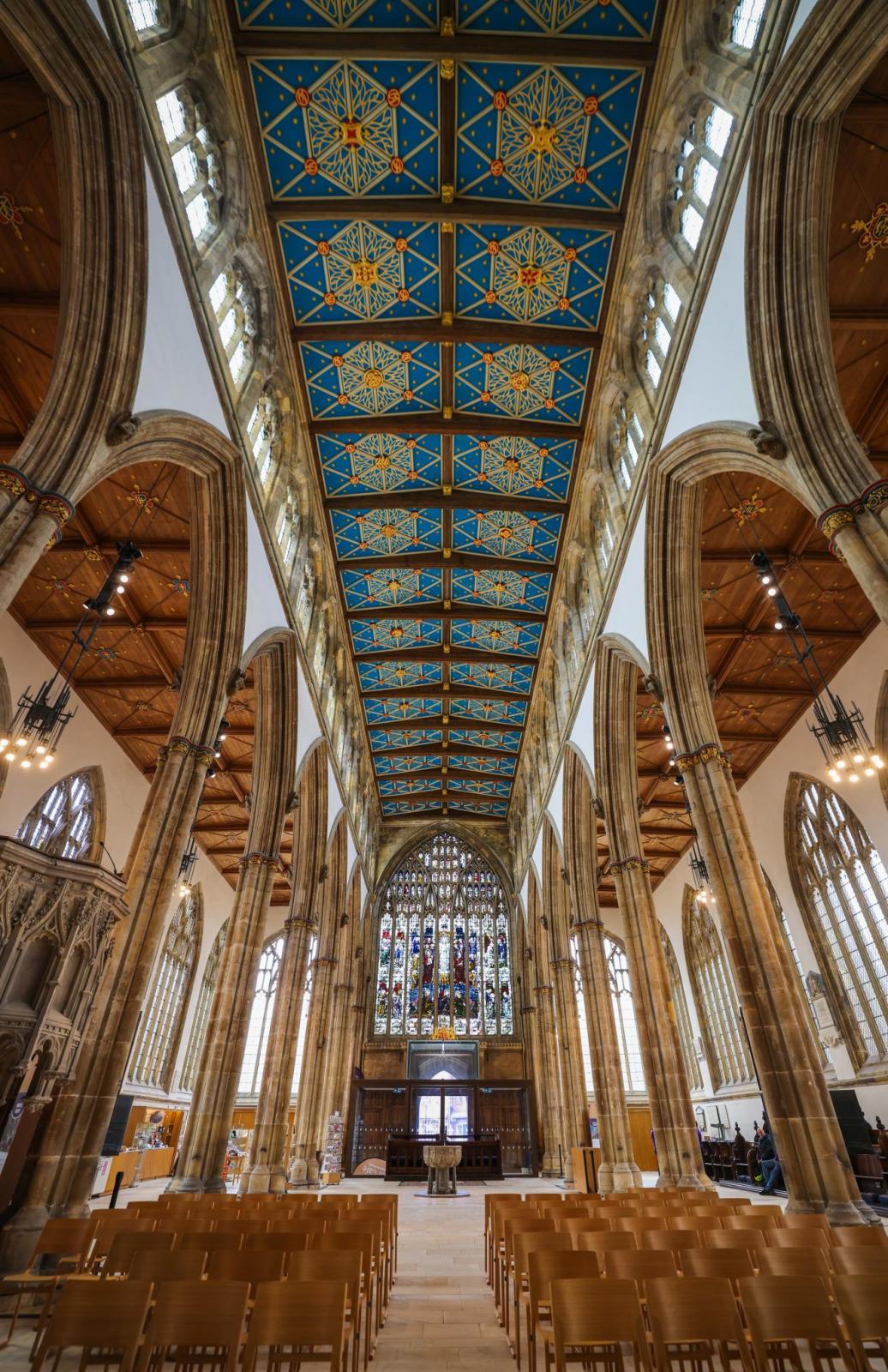 Looking up inside to the intricate ornate ceiling of an old church.