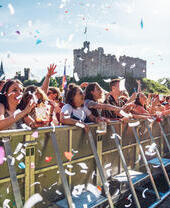 A group of people at the barrier at a music stage at Tafwyl, an annual music festival inside the grounds of Cardiff Castle