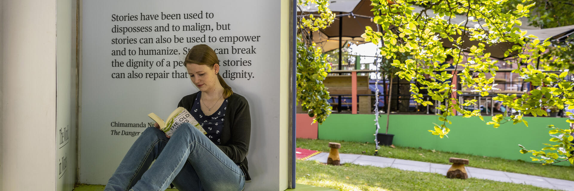 Frau, die bei einem Buchfestival sitzend liest