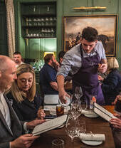 A group of people being waited on at a table in The Elder, Bath