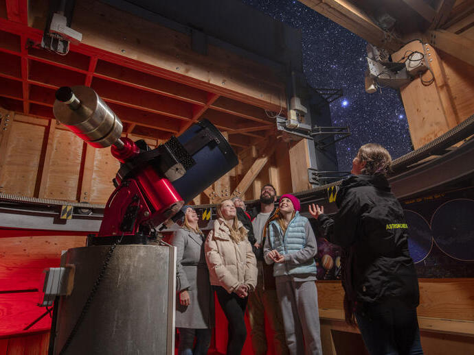 Une famille se tient avec un guide touristique à un observatoire