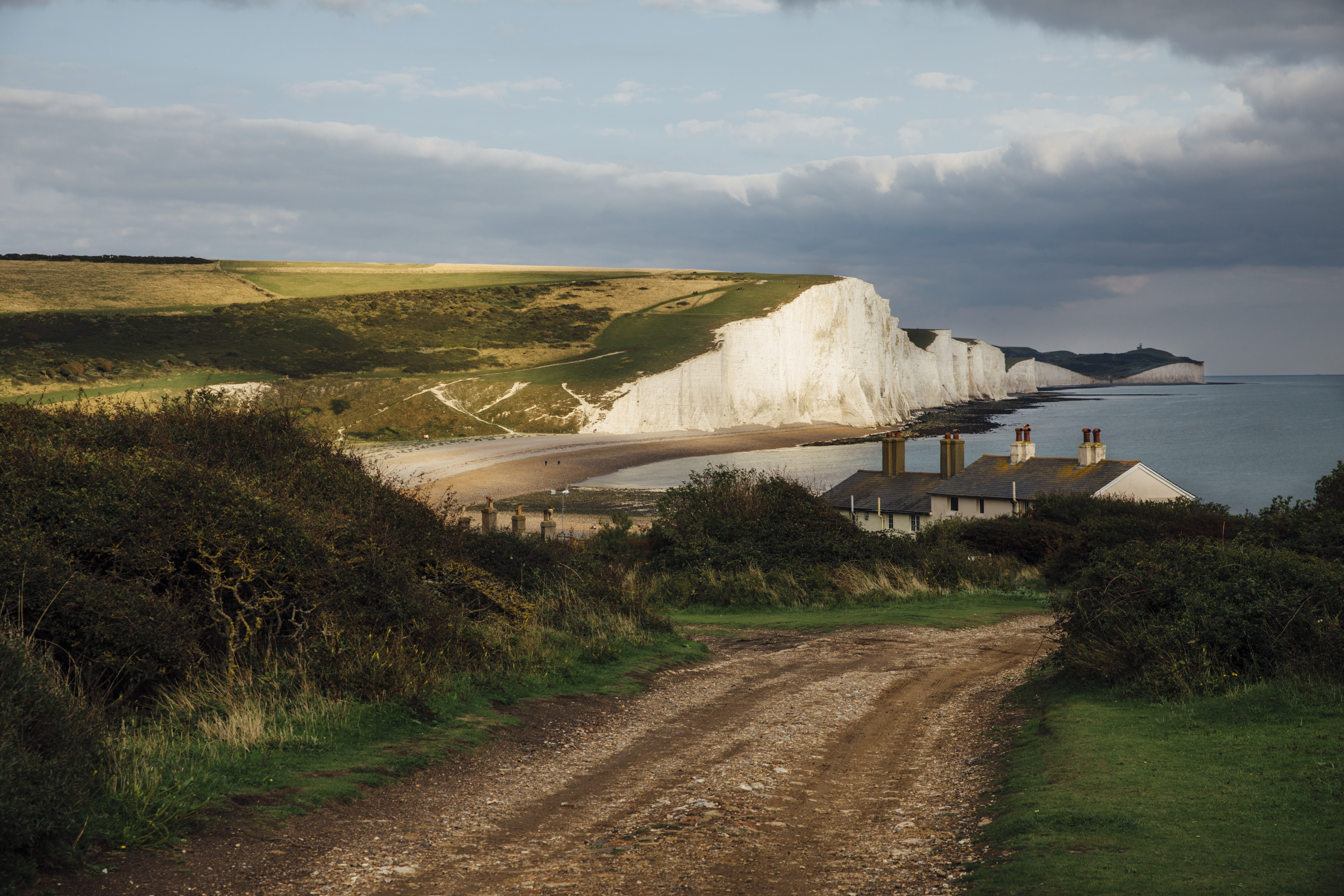 Cabañas en la costa con el mar y acantilados blancos al fondo
