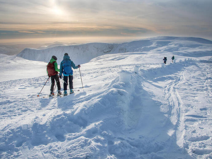 Gente esquiando en la nieve en la cresta de una montaña.