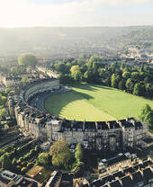 Vue aérienne d'un bâtiment en forme de croissant entouré d'herbe