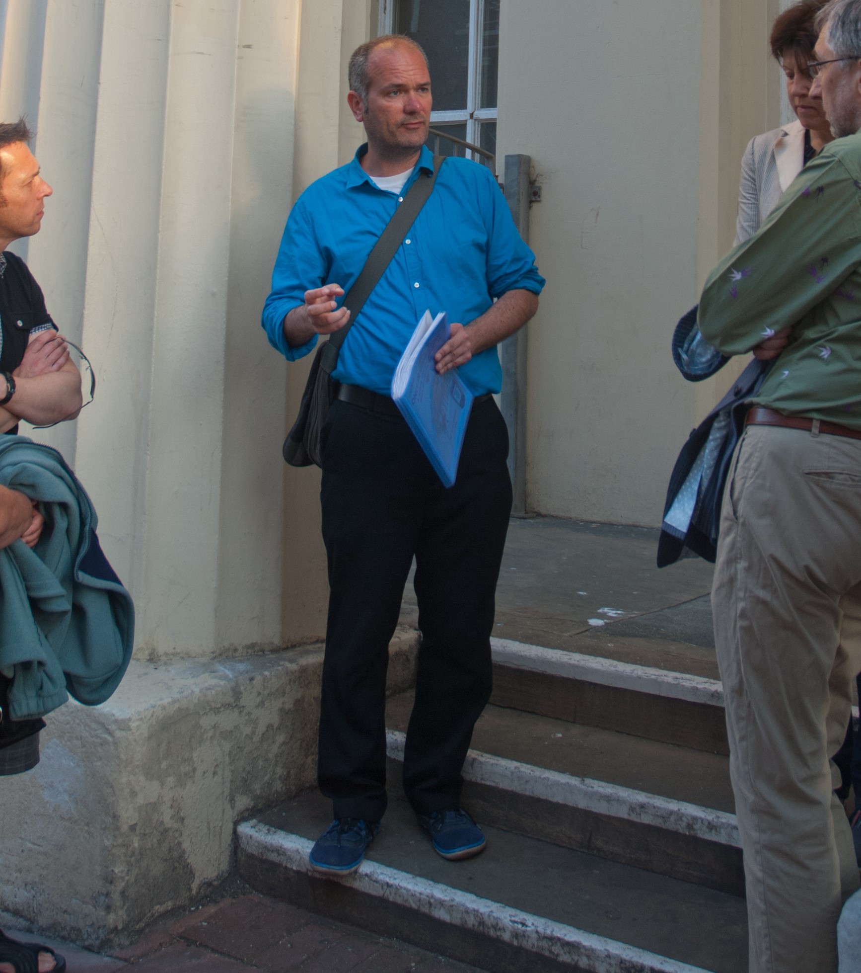 A tour guide talking to a group outside a historic building in Brighton