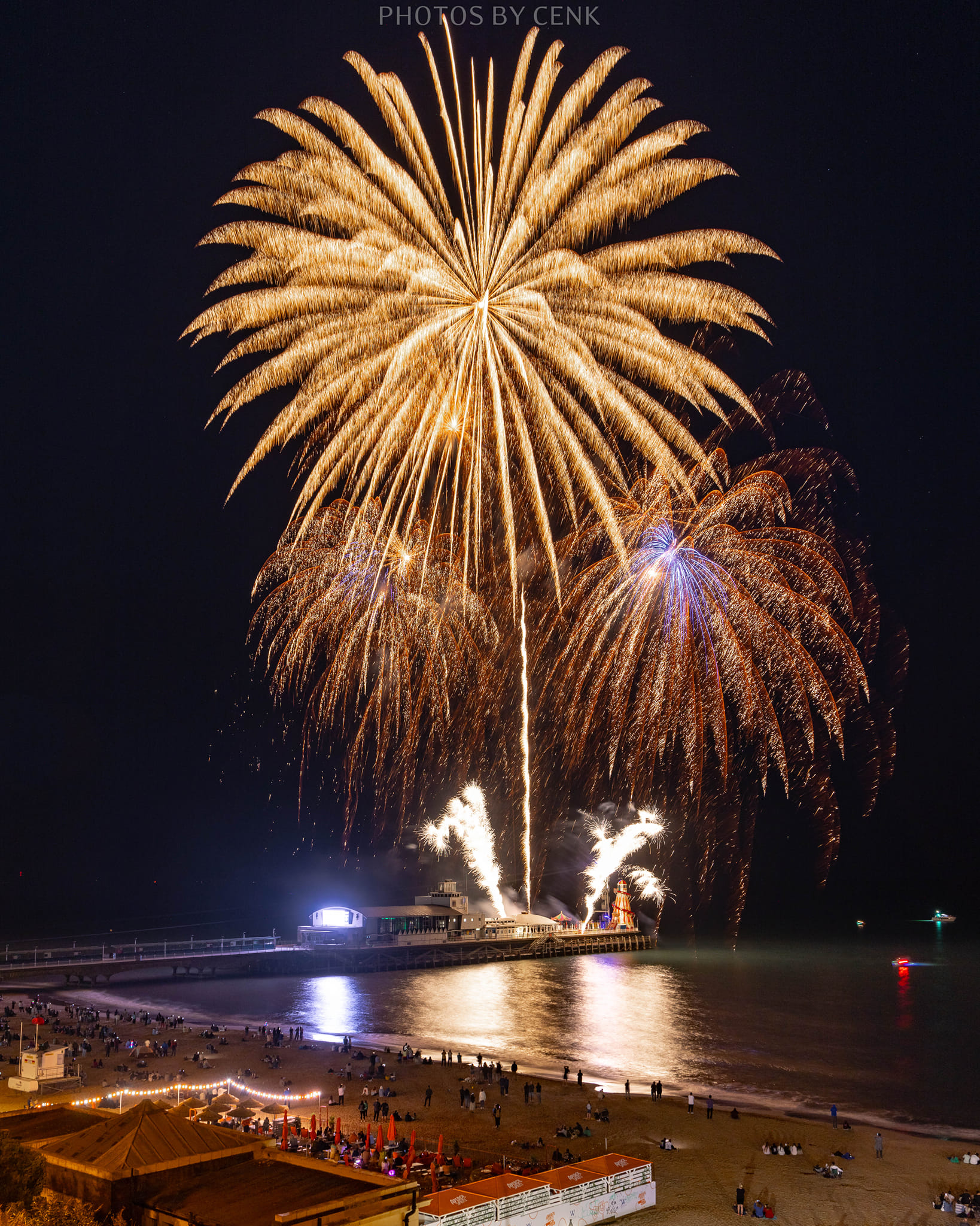 A fireworks display taking place on a seaside pier.