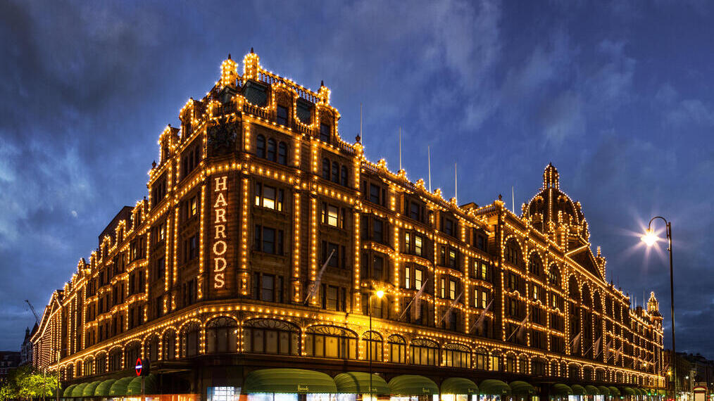 Harrods department store lit up at night. Dark skies